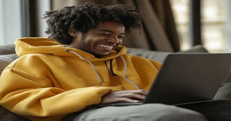 A person happily working on a laptop in a modern workspace, symbolizing online marketing success and financial independence